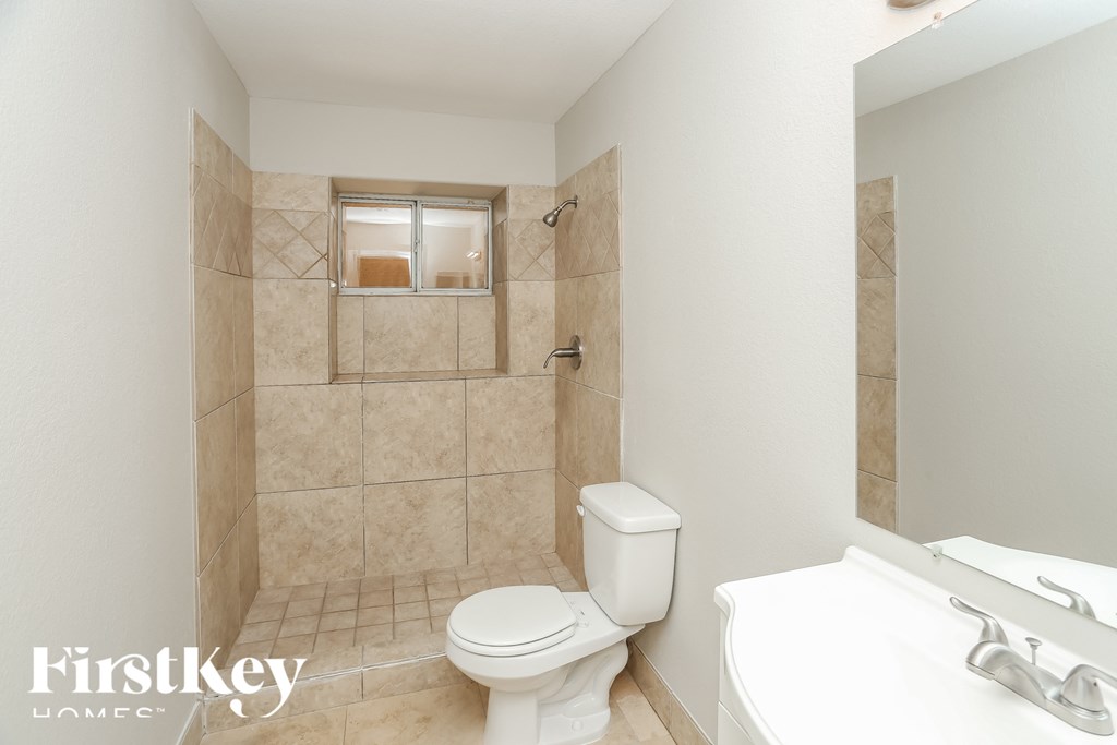 a bathroom with a toilet and a sink and a shower