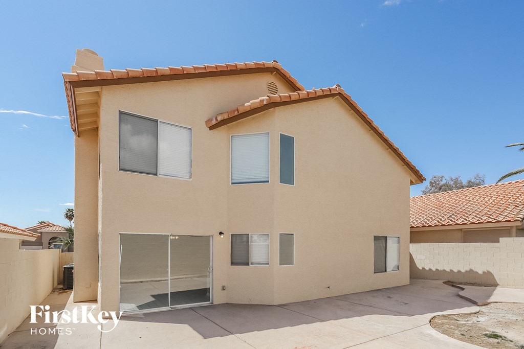 a beige house with a garage and a driveway in front of it