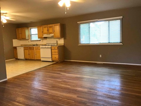 A kitchen with wooden cabinets and a white stove top oven.