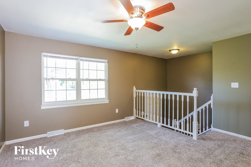 the master bedroom has a large window and a ceiling fan