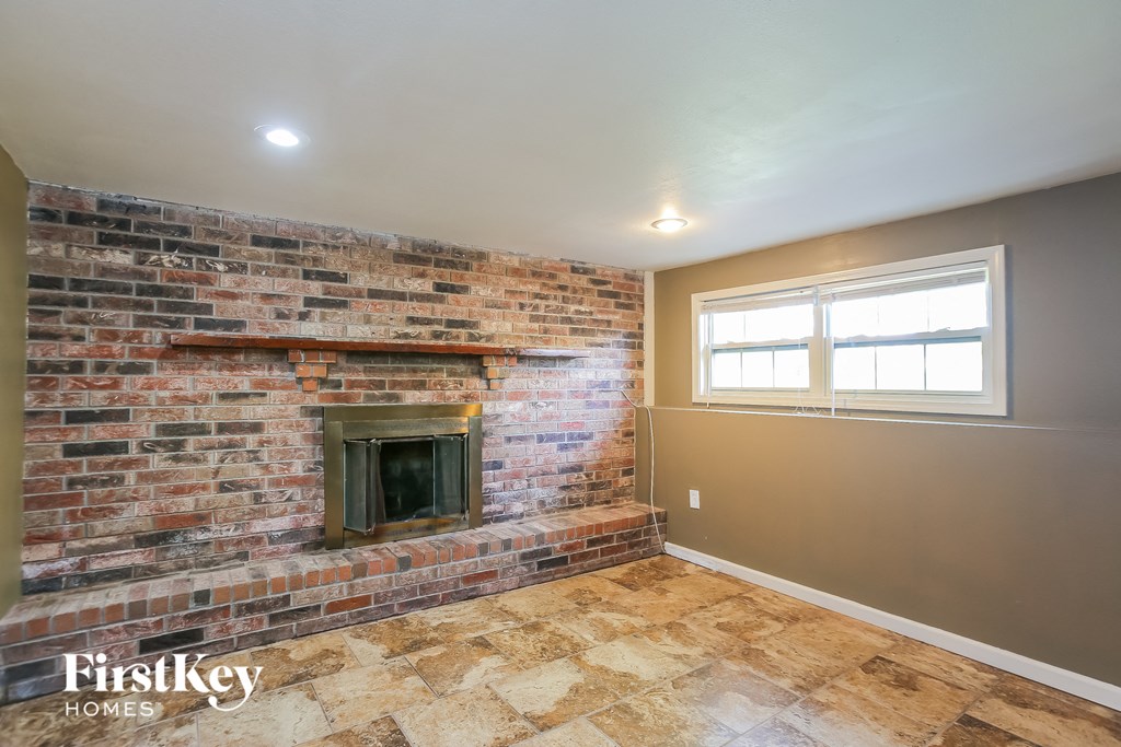 the living room has a brick fireplace and a window