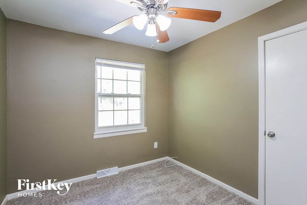a bedroom with a ceiling fan and a window