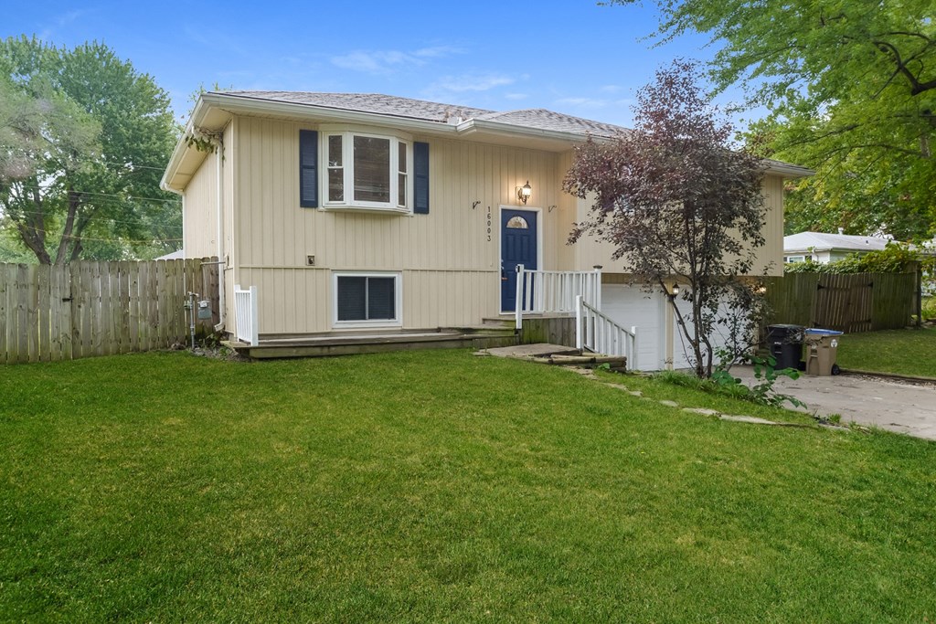 A house with a blue door and a white fence.