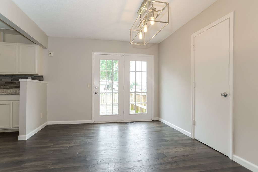 A room with a wooden floor and a white door.