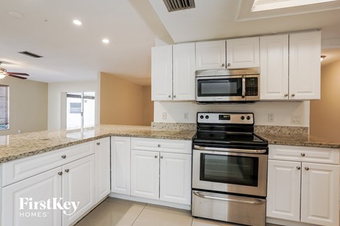 A kitchen with white cabinets and a stainless steel oven.