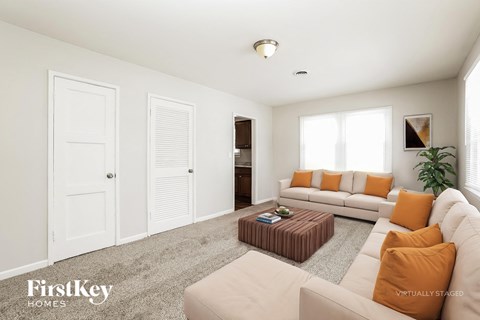 A living room with a white couch and a brown coffee table.