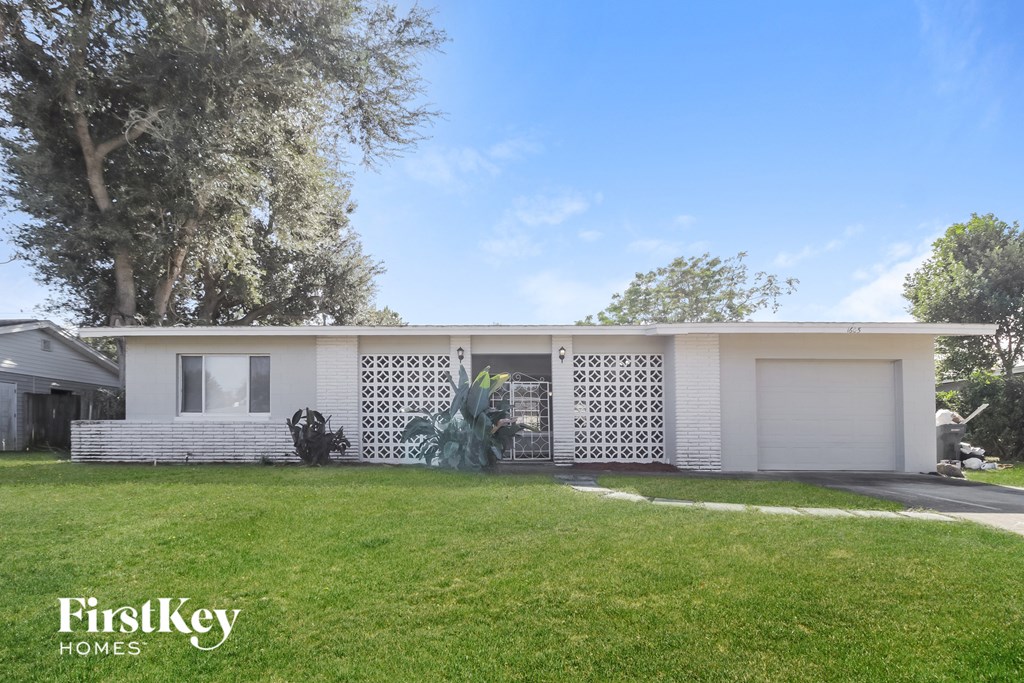 a white house with a lawn and a white garage door