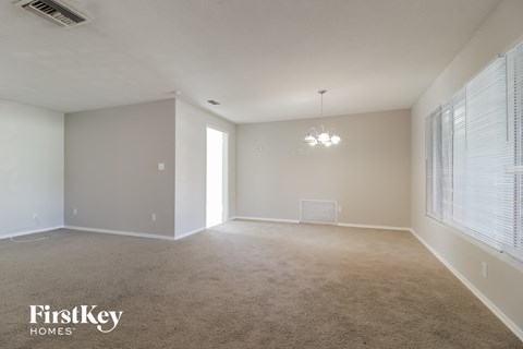 a spacious living room with carpet and a window