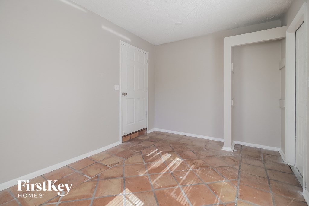 the living room of a home with tile flooring and a white door