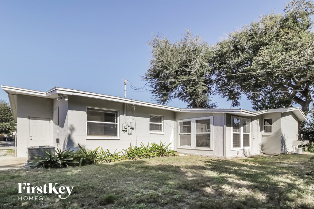 a white house with a lawn and a tree
