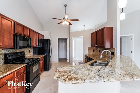a kitchen with black appliances and granite counter tops