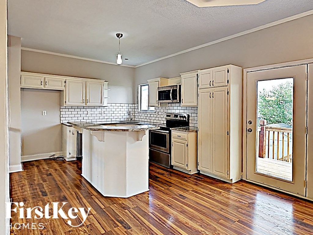 A kitchen with wooden floors and white appliances.