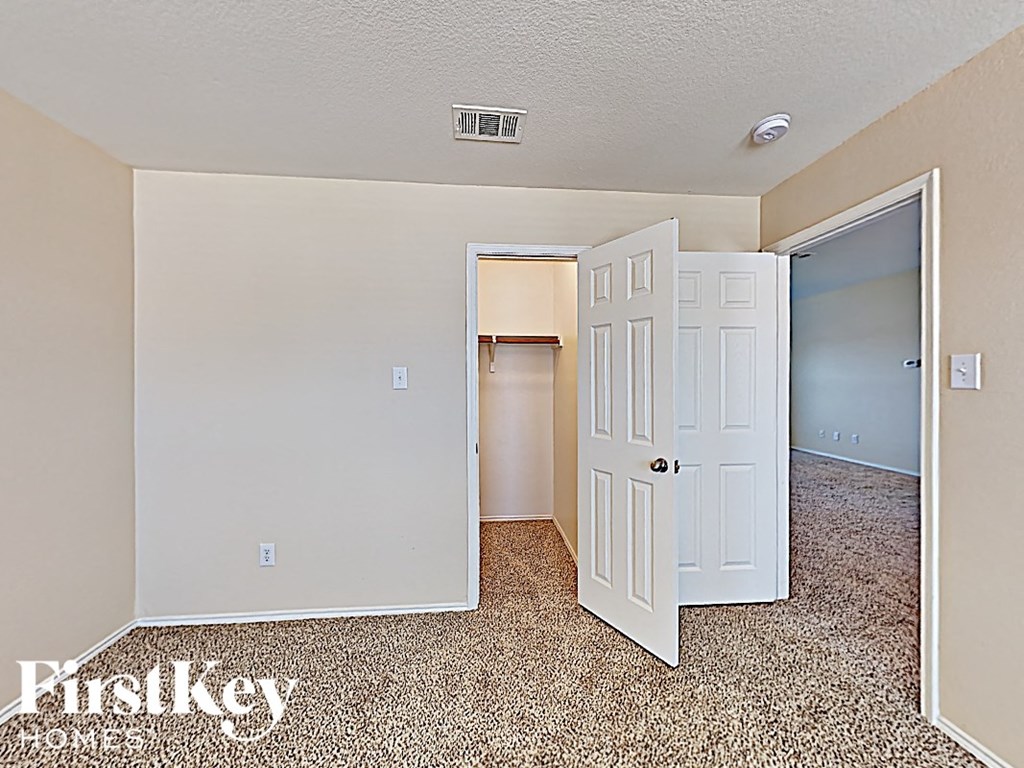 a bedroom with an open door and a closet