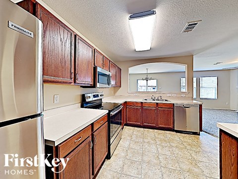 an updated kitchen with wood cabinets and stainless steel appliances