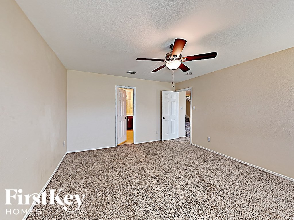 the living room of an empty house with a ceiling fan