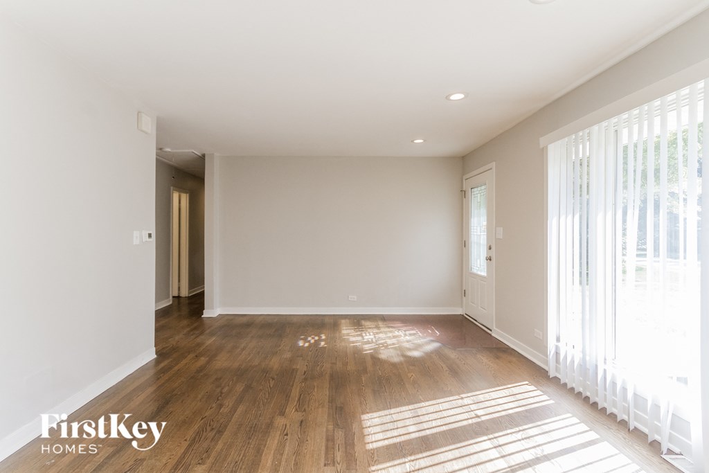 a renovated living room with wood floors and white walls
