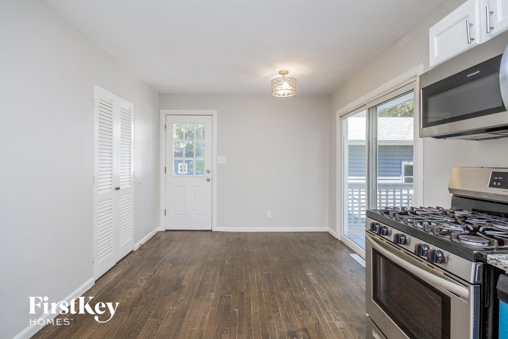 an empty kitchen and living room with a stove and a window