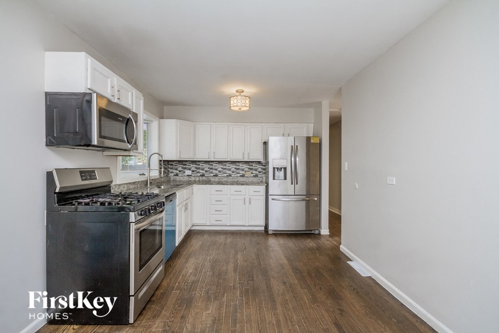 a kitchen with stainless steel appliances and white cabinets