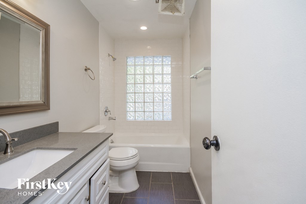 a white bathroom with a white toilet and a tub and a sink
