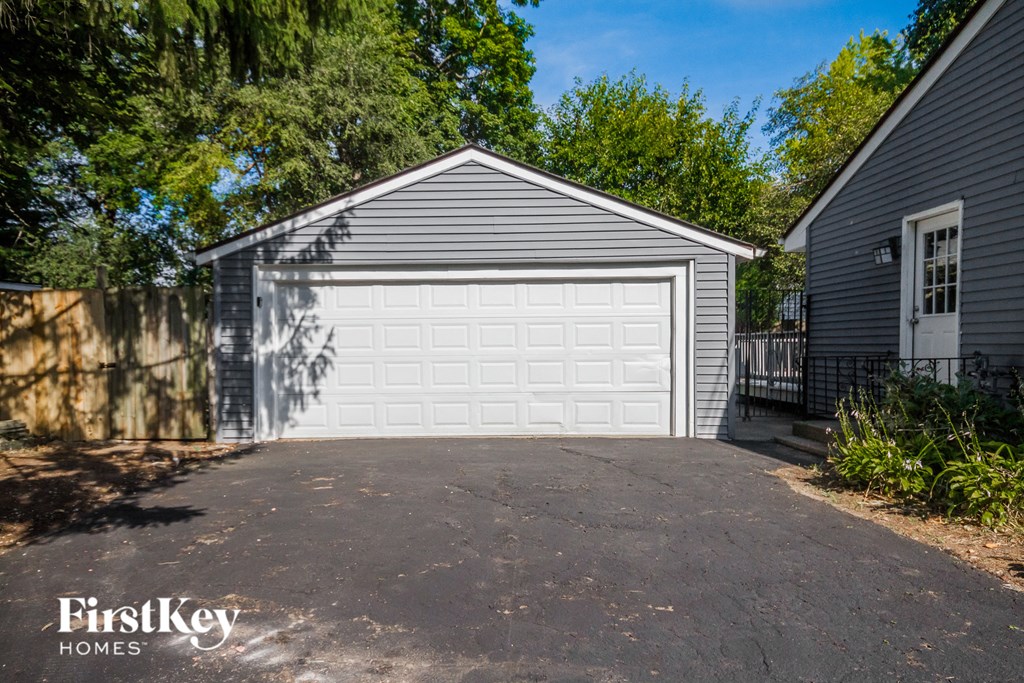 a white garage door on a driveway in front of a house