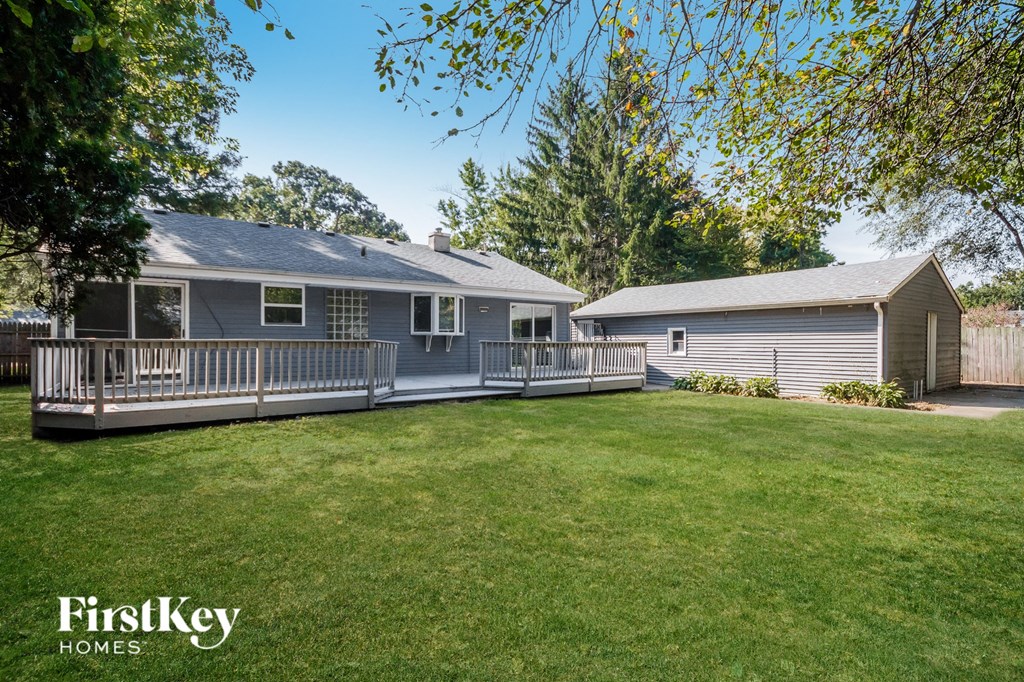 a house with a yard and a deck and a fence