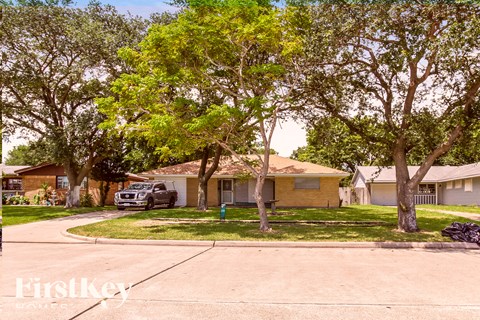A residential street with houses and trees.