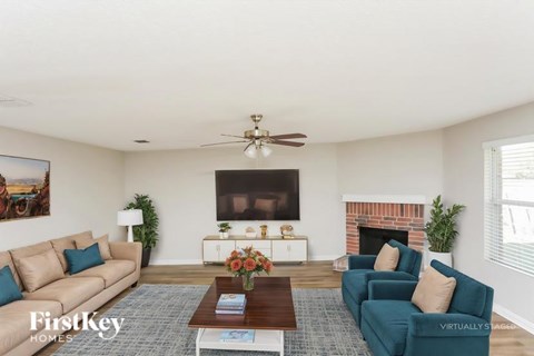 A living room with a fireplace and a painting on the wall.
