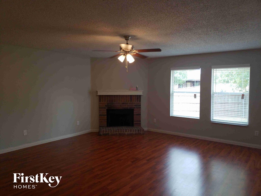 A room with a fireplace and a ceiling fan.