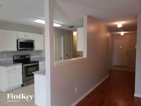 A kitchen with white cabinets and a microwave above the stove.