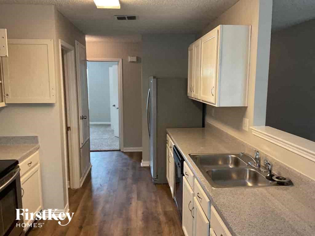 A kitchen with wooden cabinets and a stainless steel refrigerator.