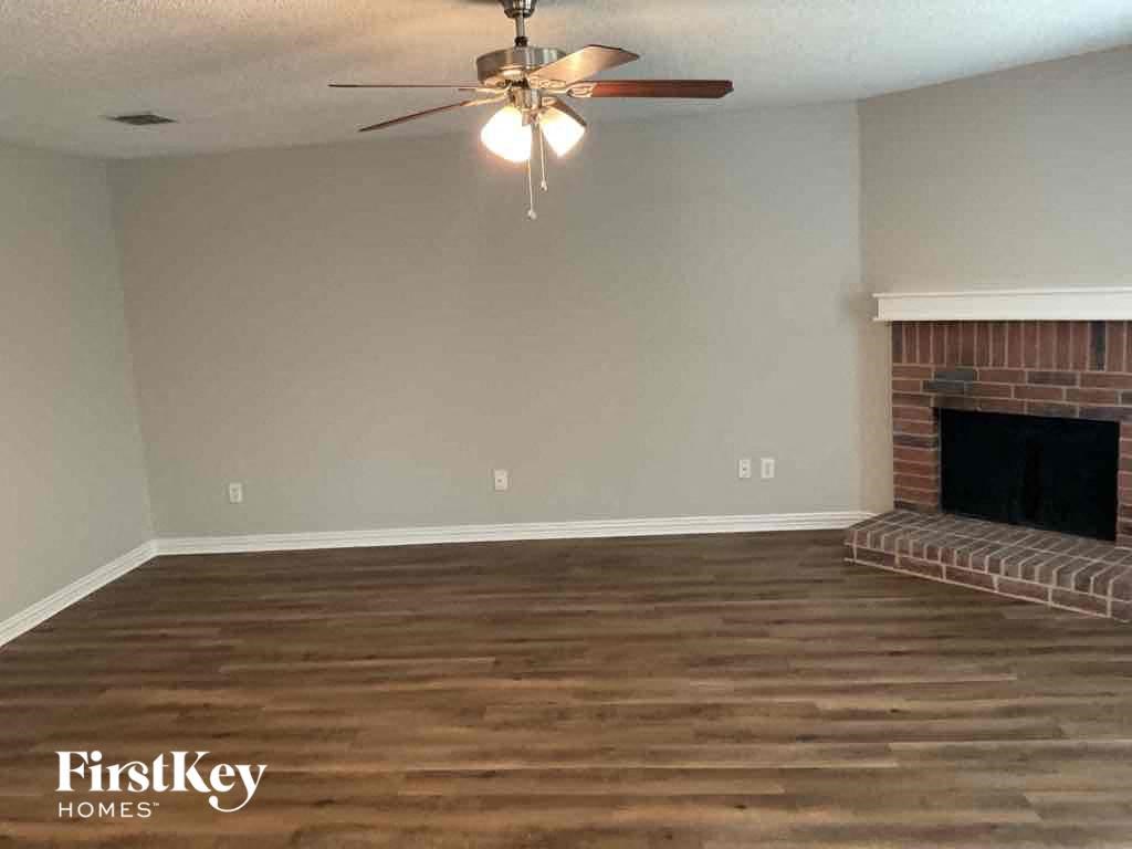 A room with a fireplace and a ceiling fan.