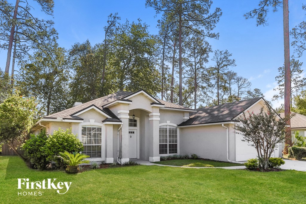 a white house with a lawn and trees
