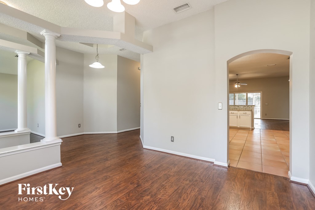 the living room and dining room with the kitchen in the background