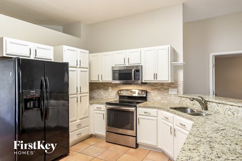a kitchen with white cabinets and stainless steel appliances