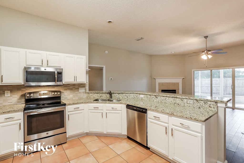 a kitchen with white cabinets and a granite counter top