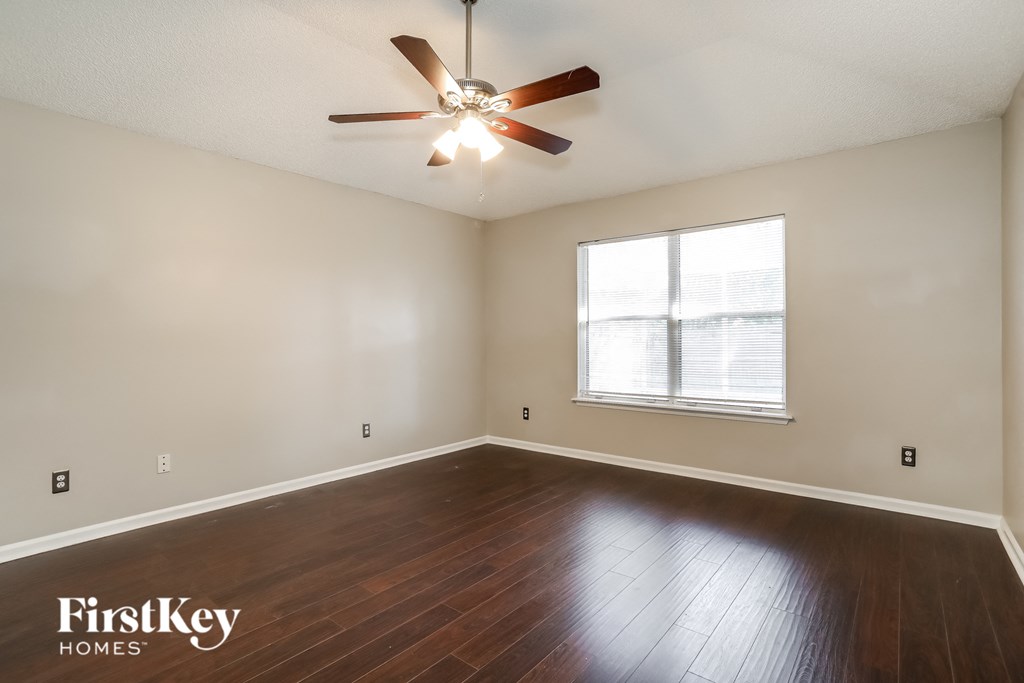a living room with wood floors and a ceiling fan