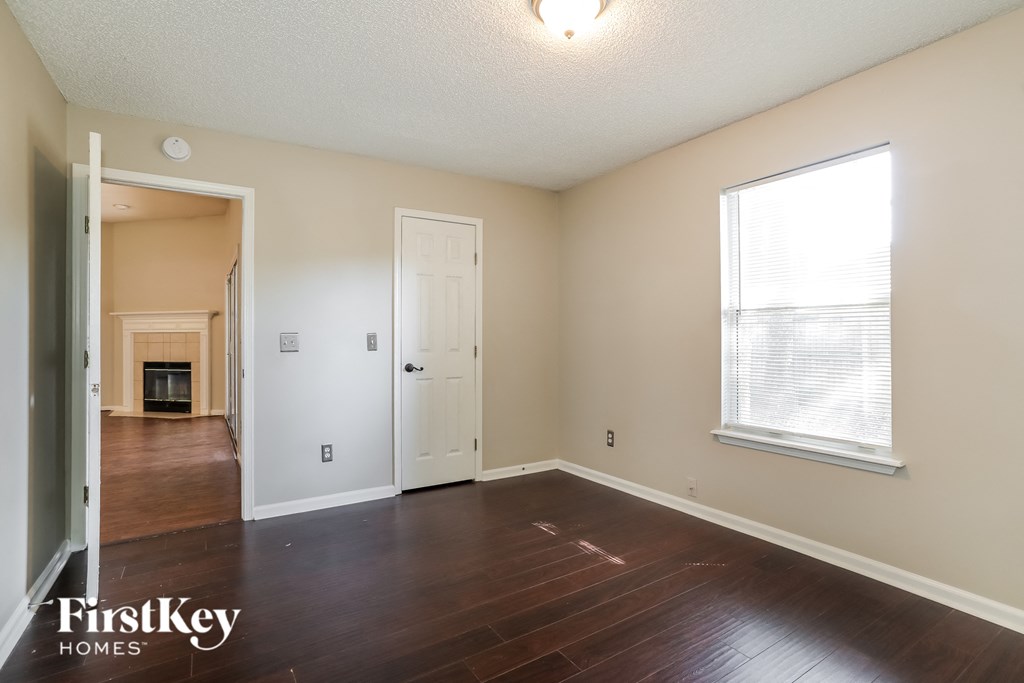 a living room with wood floors and a white door and a window