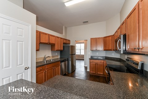 full view of kitchen with granite counter tops and wooden cabinets