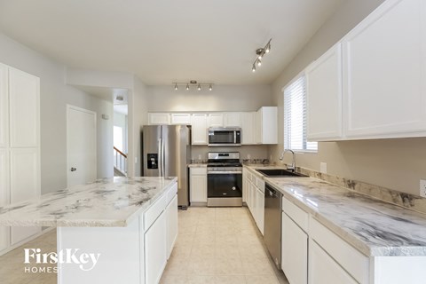 a large kitchen with marble counter tops and stainless steel appliances