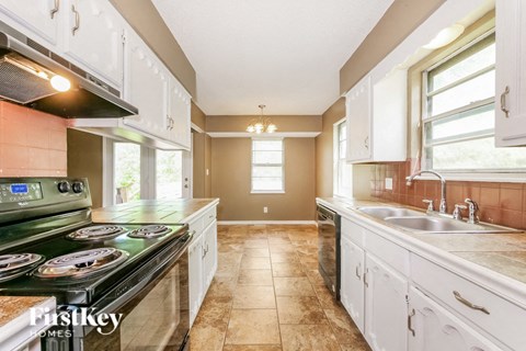 A kitchen with a stove top oven and a sink.