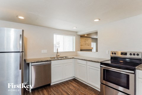 a kitchen with white cabinets and stainless steel appliances