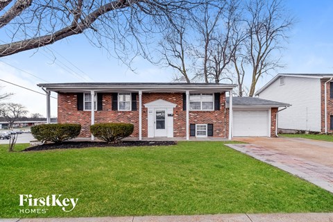 a brick house with a white front door and a lawn
