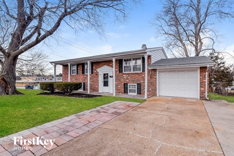 a brick house with a white garage door on a driveway