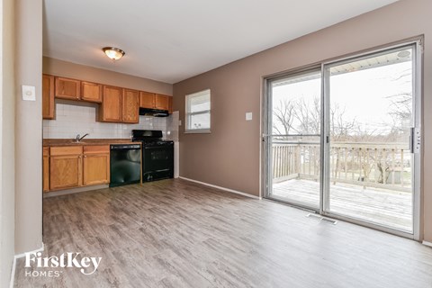 an empty kitchen with a sliding glass door to a deck