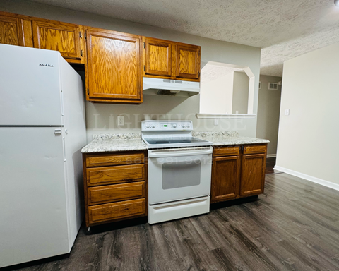 a kitchen with white appliances and wooden cabinets