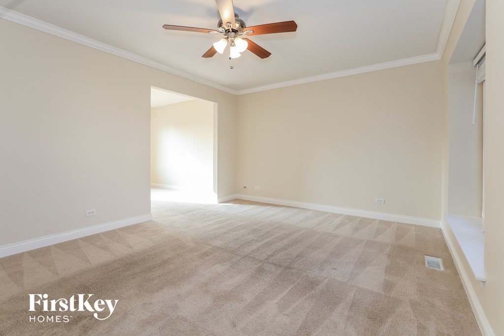 a empty living room with a ceiling fan