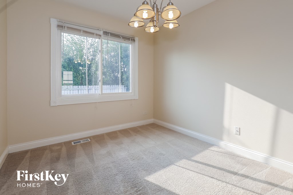a bedroom with a large window and a carpeted floor