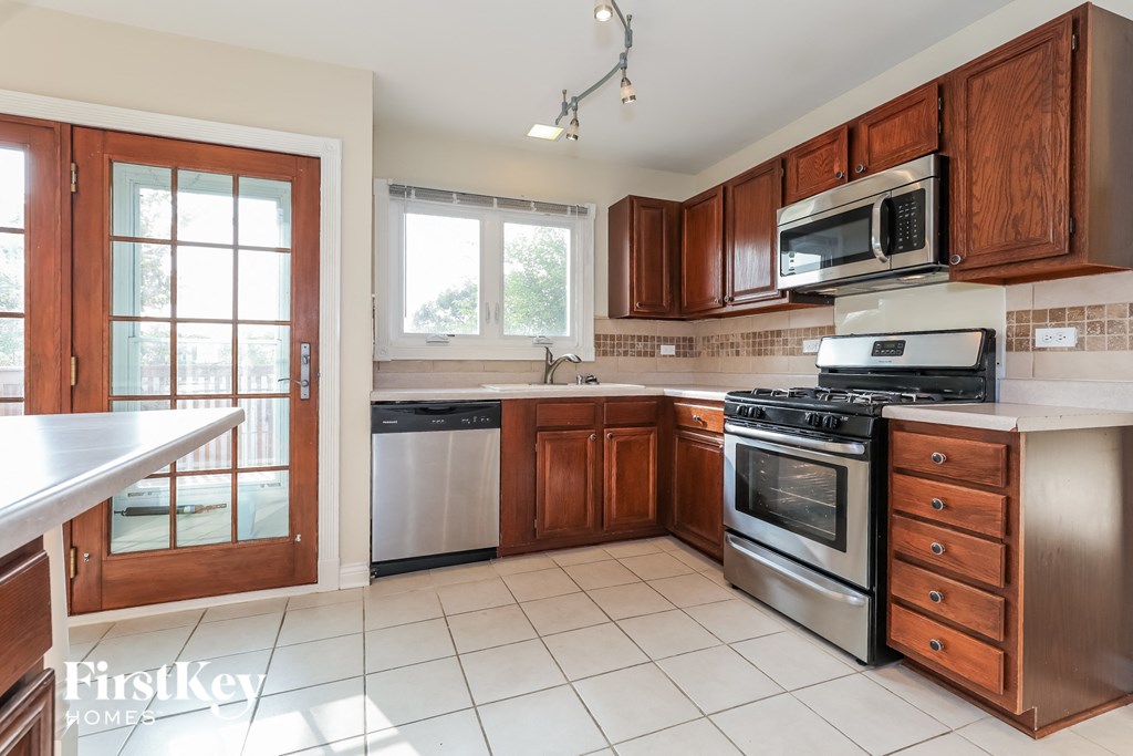 a kitchen with wooden cabinets and stainless steel appliances