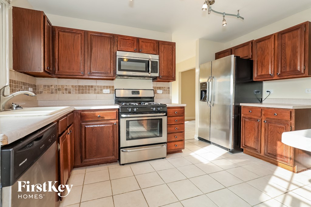 a kitchen with wooden cabinets and stainless steel appliances