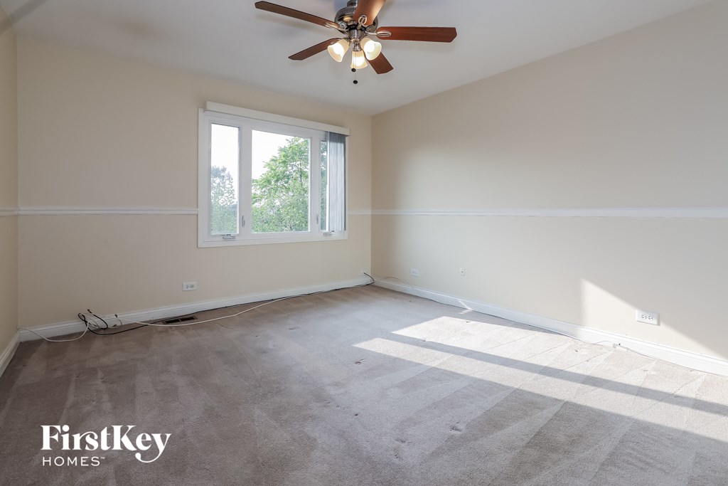 a empty room with a ceiling fan and a window